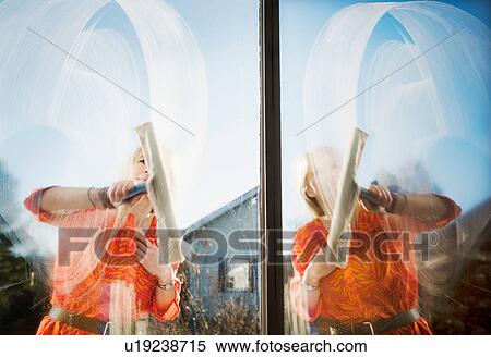Stock Photography - Composite of woman outdoors cleaning windows with squeegee. Fotosearch