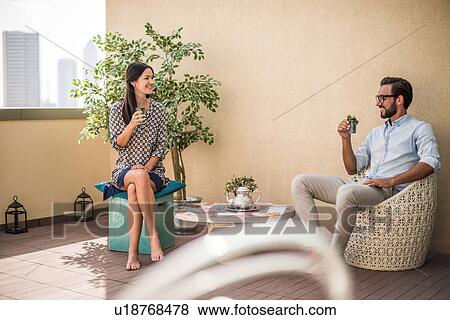 Stock Photo - Couple drinking mint tea on hotel room balcony, Dubai, United Arab Emirates. Fotosearch