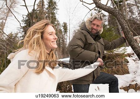 Couple hiking in winter landscape, holding hands, smiling View Large Photo Image Stock Image - Couple hiking in winter landscape, holding hands, smiling. Fotosearch