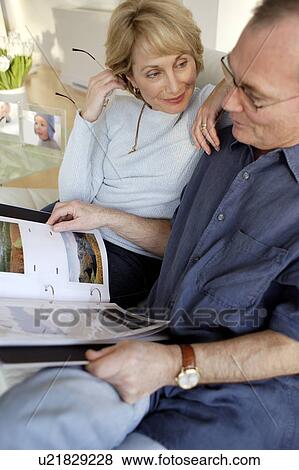 Couple looking at photographs View Large Photo Image Stock Photo - Couple looking at photographs. Fotosearch
