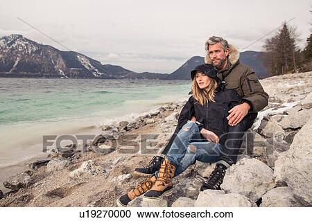 Couple sitting beside lake, looking at view, German Alps, Germany View Large Photo Image Stock Image - Couple sitting beside lake, looking at view, German Alps, Germany. Fotosearch