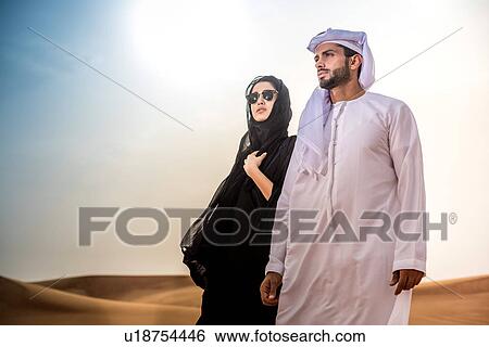 Couple wearing traditional middle eastern clothes in desert, Dubai, United Arab Emirates View Large Photo Image Stock Photograph - Couple wearing traditional middle eastern clothes in desert, Dubai, United Arab Emirates. Fotosearch