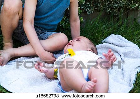 Cropped shot of baby boy gazing at brother in garden View Large Photo Image Stock Photo - Cropped shot of baby boy gazing at brother in garden. Fotosearch