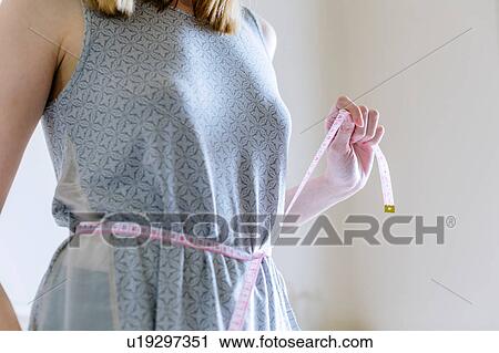 Cropped view of woman measuring waist with tape measure View Large Photo Image Stock Image - Cropped view of woman measuring waist with tape measure. Fotosearch