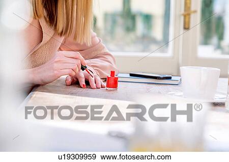 Cropped view of woman painting nail with red nail varnish View Large Photo Image Stock Photo - Cropped view of woman painting nail with red nail varnish. Fotosearch