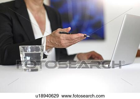 Cropped view of woman using laptop holding pen View Large Photo Image Stock Photo - Cropped view of woman using laptop holding pen. Fotosearch