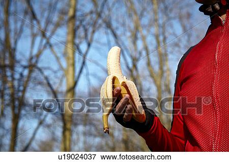 Cropped view of woman wearing fingerless gloves holding banana View Large Photo Image Stock Photo - Cropped view of woman wearing fingerless gloves holding banana. Fotosearch