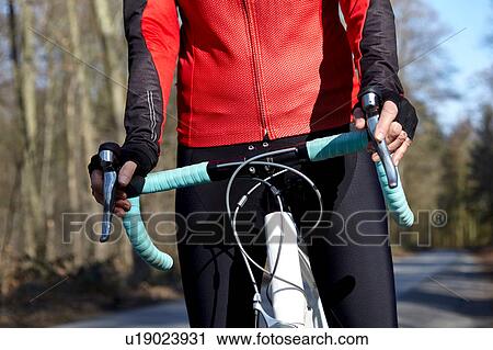 Stock Image - Cropped view of womans mid section on mountain bike. Fotosearch