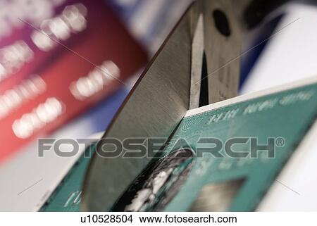 Picture - Cutting up a credit card. Fotosearch