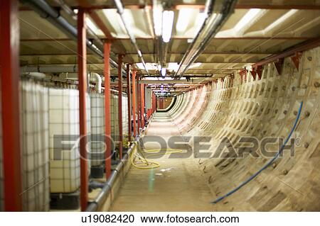 Stock Image - Diminishing perspective of corridor storing water tanks. Fotosearch