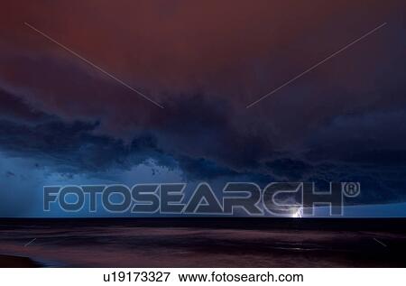 Stock Photo - Distant lightning hitting water over the Atlantic Ocean, at night, near Satellite Beach, Florida, USA. Fotosearch