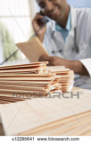 Doctor discussing medical records View Large Photo Image Stock Image - Doctor discussing medical records. Fotosearch