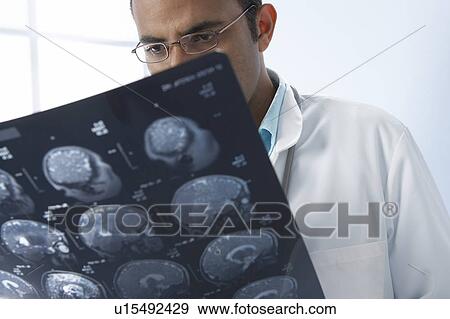 Doctor examining MRI scans View Large Photo Image Stock Photo - Doctor examining MRI scans. Fotosearch