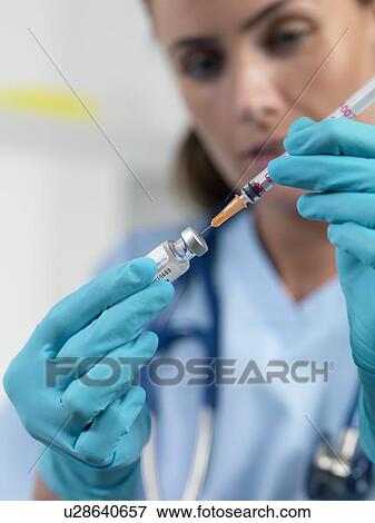 Doctor filling a syringe View Large Photo Image Stock Photo - Doctor filling a syringe. Fotosearch