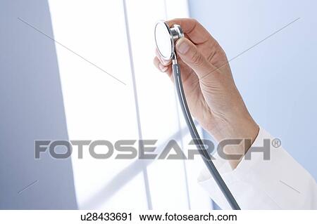 Stock Image - Doctor holding a stethoscope. Fotosearch