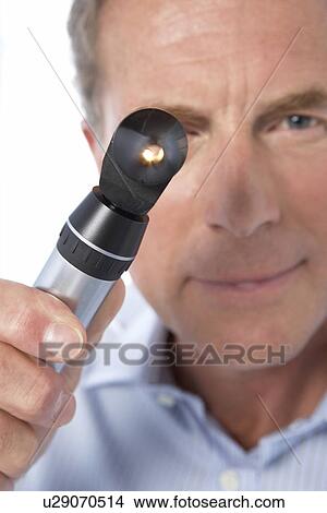 Picture - Doctor holding an otoscope. Fotosearch