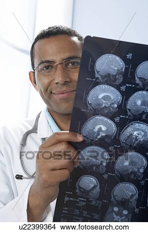 Doctor holding MRI scans View Large Photo Image Picture - Doctor holding MRI scans. Fotosearch