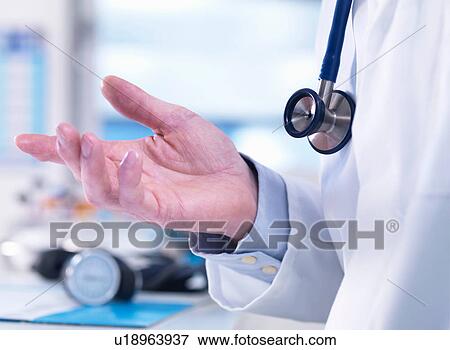 Stock Photo - Doctor offering advice to a patient in a clinic. Fotosearch