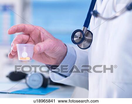 Doctor passing a cup of drugs to a patient View Large Photo Image Stock Image - Doctor passing a cup of drugs to a patient. Fotosearch