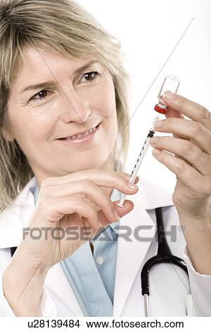 Doctor preparing a syringe View Large Photo Image Picture - Doctor preparing a syringe. Fotosearch