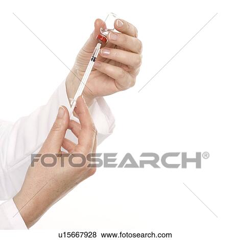 Doctor preparing a syringe View Large Photo Image Stock Photo - Doctor preparing a syringe. Fotosearch