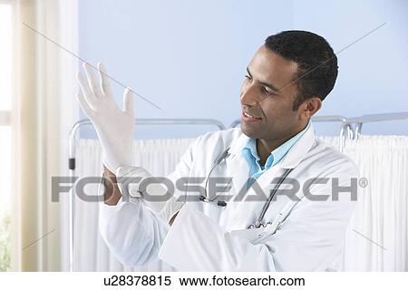Doctor putting on latex gloves View Large Photo Image Stock Photography - Doctor putting on latex gloves. Fotosearch