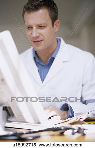 Stock Photography - Doctor typing notes. Fotosearch