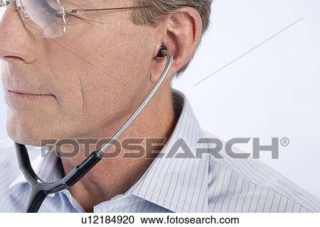 Doctor using a stethoscope View Large Photo Image Stock Image - Doctor using a stethoscope. Fotosearch