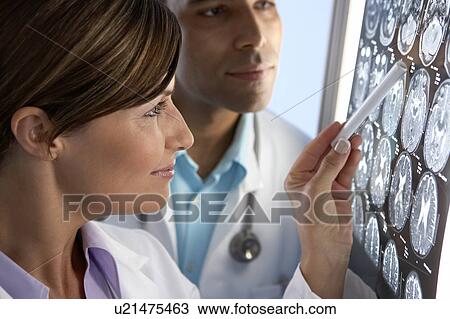 Stock Image - Doctors examining MRI scans. Fotosearch