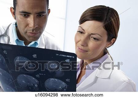 Stock Photo - Doctors examining MRI scans. Fotosearch