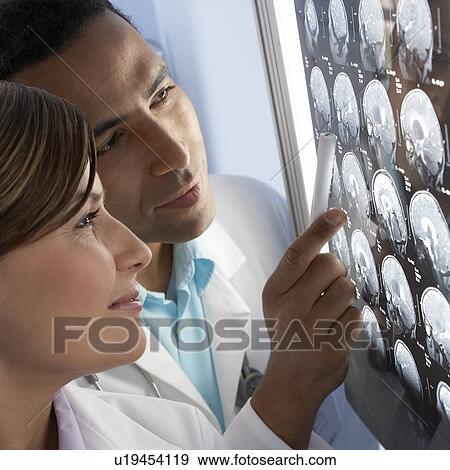 Stock Photo - Doctors examining MRI scans. Fotosearch