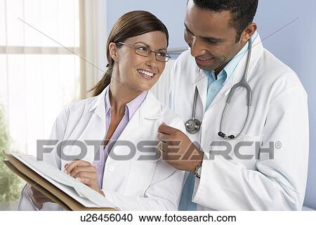 Stock Image - Doctors smiling at each other. Fotosearch