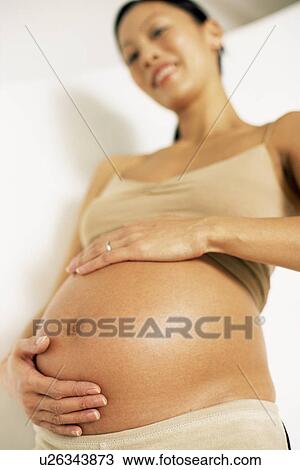 Stock Image - Eight month pregnant woman. Fotosearch
