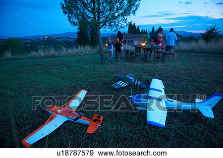Family in field at dusk, remote control planes in foreground View Large Photo Image Stock Photo - Family in field at dusk, remote control planes in foreground. Fotosearch