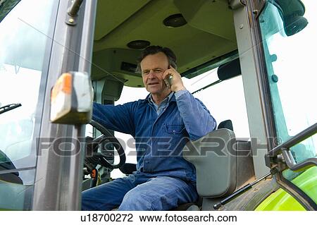 Farmer talking in tractor on smartphone View Large Photo Image Stock Image - Farmer talking in tractor on smartphone. Fotosearch
