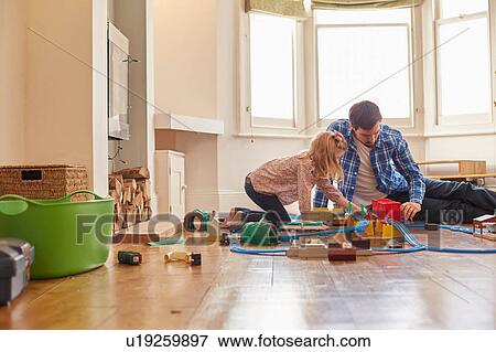 Stock Photo - Father and daughter playing with toy train set. Fotosearch