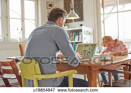 Stock Photo - Father and son working in home office. Fotosearch