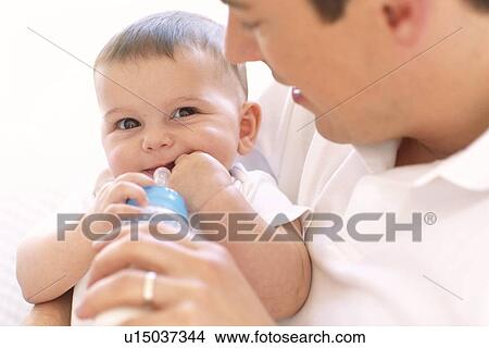 Father bottle-feeding baby girl View Large Photo Image Picture - Father bottle-feeding baby girl. Fotosearch