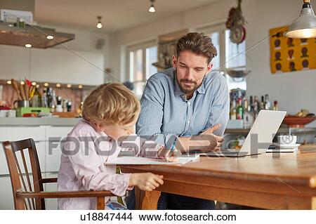 Father helping son with homework in home office View Large Photo Image Picture - Father helping son with homework in home office. Fotosearch