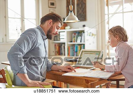 Father helping son with homework in home office View Large Photo Image Stock Image - Father helping son with homework in home office. Fotosearch
