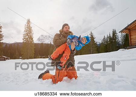 Father lifting up son in snow, Elmau, Bavaria, Germany View Large Photo Image Picture - Father lifting up son in snow, Elmau, Bavaria, Germany. Fotosearch