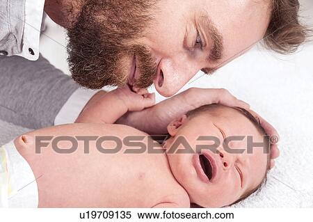 Stock Photography - Father touching newborn baby. Fotosearch