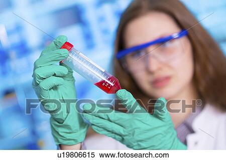 Stock Photography - Female chemist holding syringe. Fotosearch
