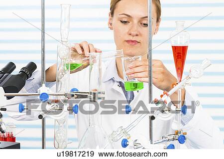 Female chemist pouring chemicals View Large Photo Image Stock Photo - Female chemist pouring chemicals. Fotosearch