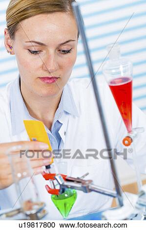 Stock Image - Female chemist working in lab. Fotosearch