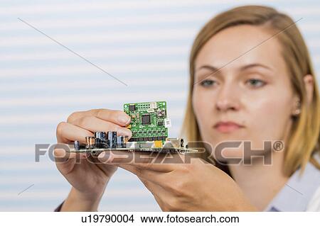 Picture - Female electrical engineer fixing circuit. Fotosearch