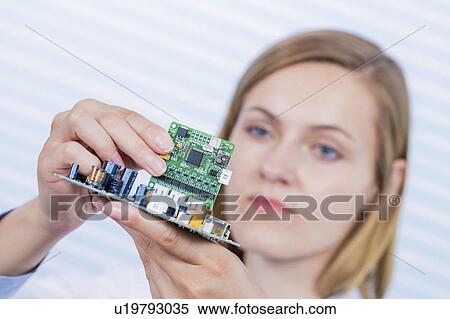 Stock Photography - Female electrical engineer fixing circuit. Fotosearch