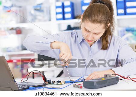 Stock Image - Female electrical engineer testing. Fotosearch