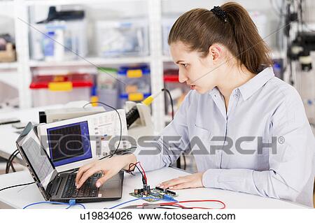 Stock Photograph - Female electrical engineer using laptop. Fotosearch