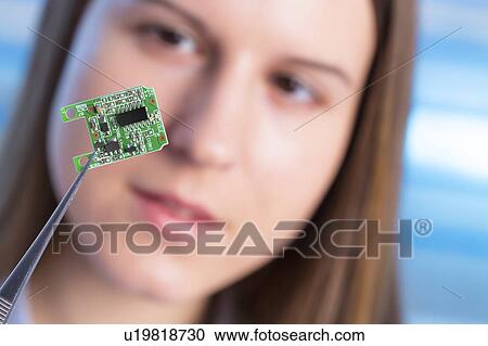Stock Image - Female electrical engineer with chip. Fotosearch